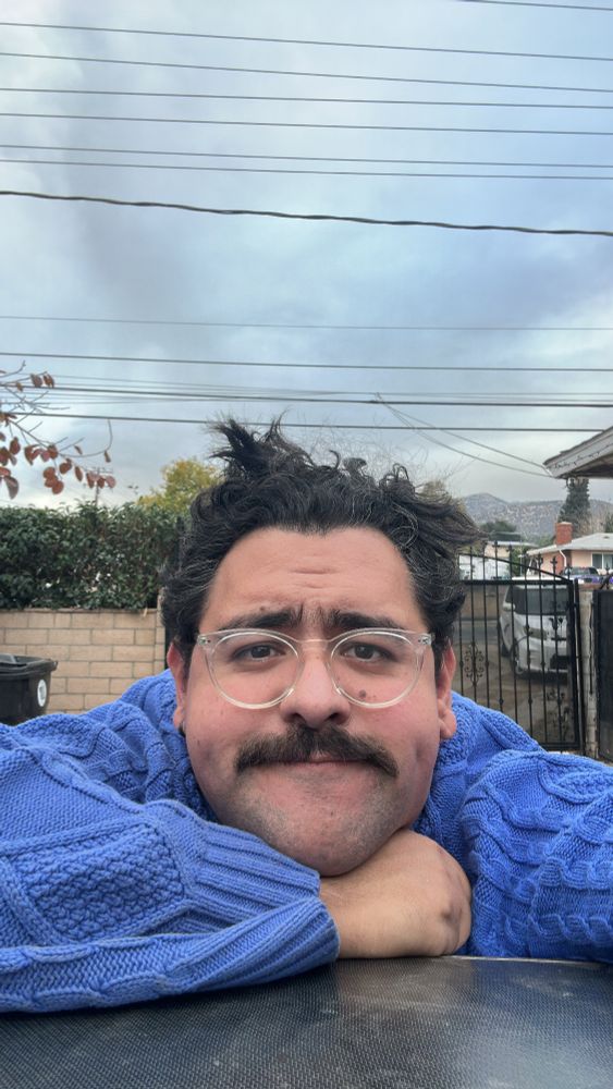 Super cute dude looking like a delicious snack with his hand under his chin. Hair looking a mess. Dimples doing all the heavy lifting. 