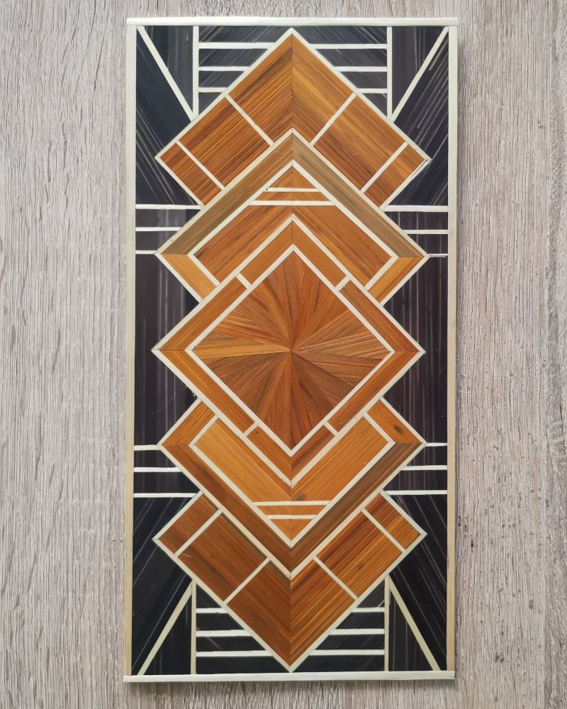 Panneau art deco en marqueterie de paille de 30*15cm.
Le motif est un entralexement de 5 carré en ligne, texturés avec des motifs différents et des césures. Les carrés sont cuivres, sur un fond anthracite. Les bordures de toutes les sections sont en paille naturelle. 