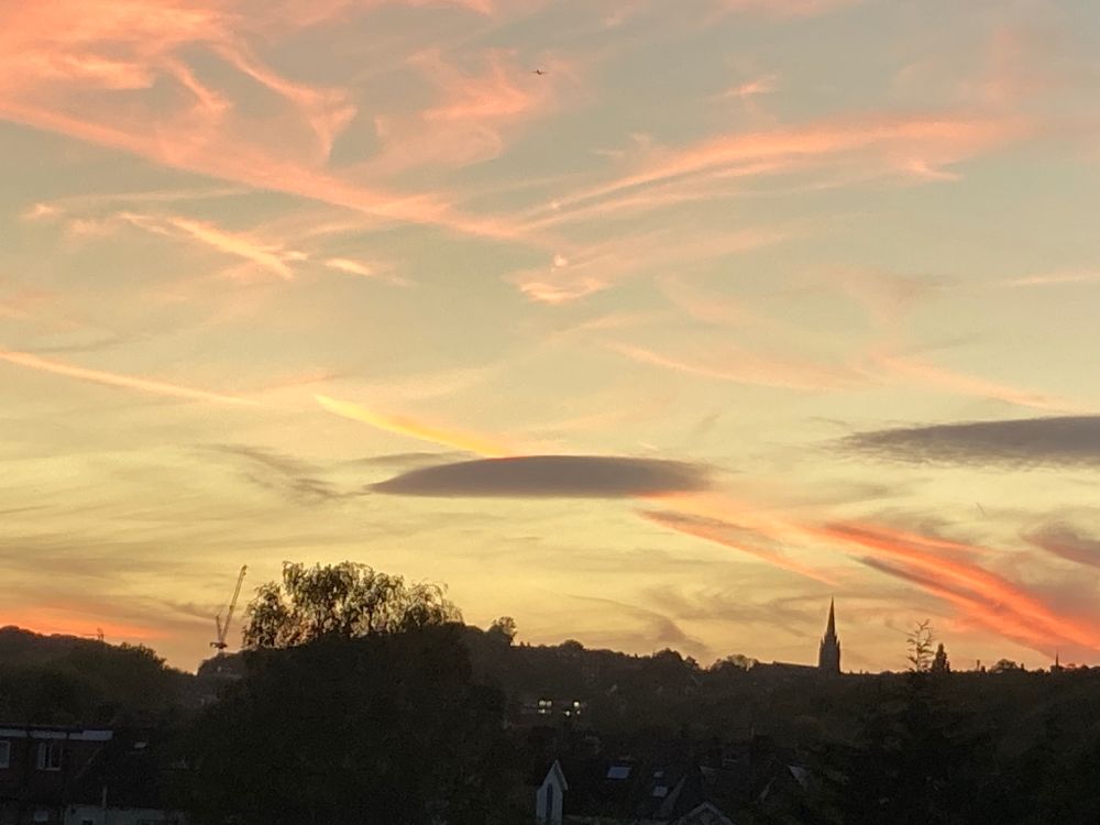 A lovely autumn sunset after a warm and sunny day. The sky is a duck-egg blue with pink and red clouds over a north London horizon.