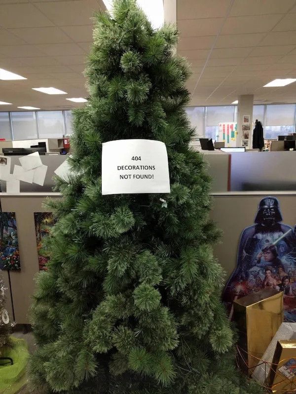 A Christmas tree with a sign on it that reads, "404 Decorations Not Found!"