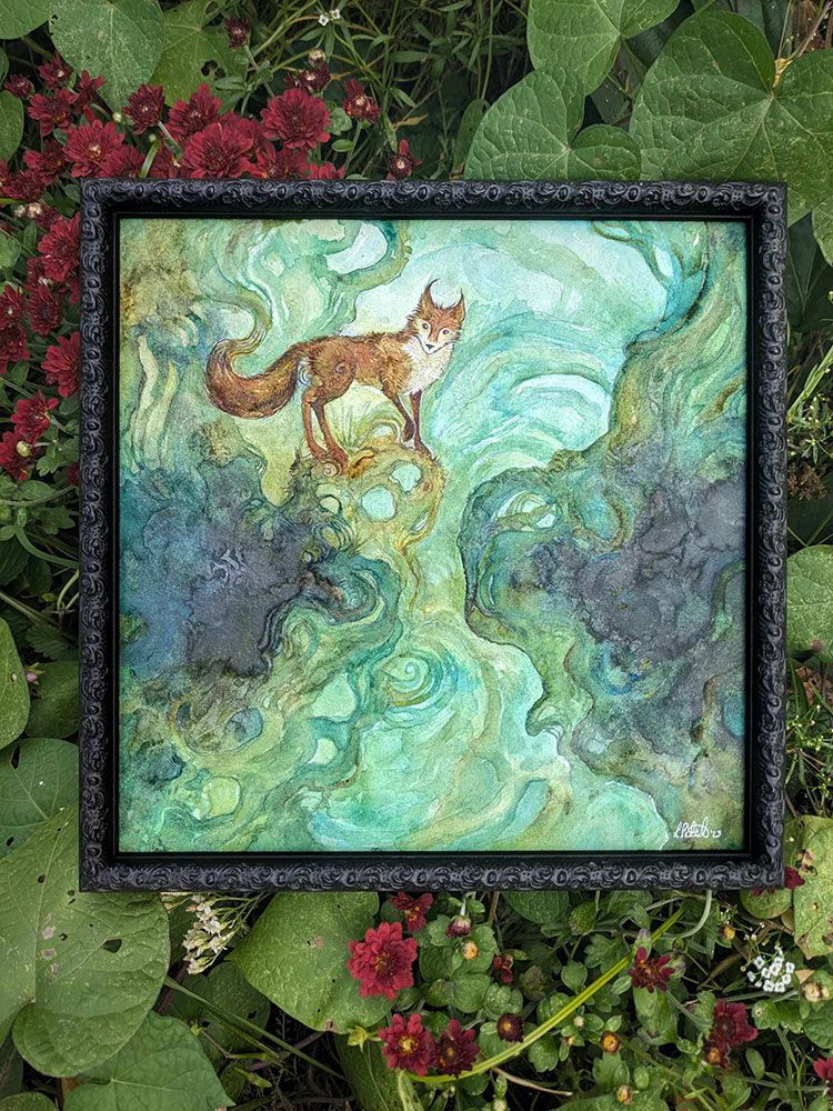 Framed watercolor painting on a bed of green leaves and dark red mums. The fox is orange and peering at the viewer curiously. Green roots surround him.