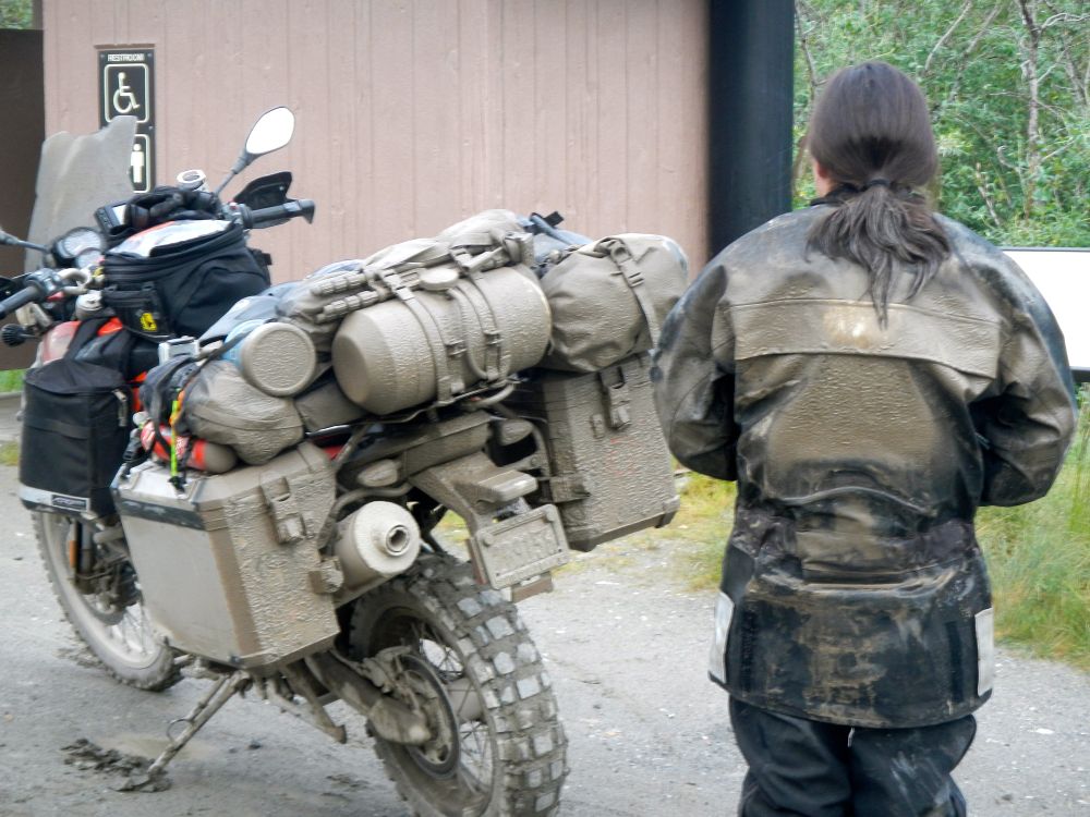 My daughter is waiting to use an bathroom next to my rather dirty motorcycle after just 2 days riding on the Dalton/Elliot Highway going north from Coldfoot AK to Deadhorse AK, USA. We spent 4 days on that gravel highway before heading south to Valdez during an epic father daughter ride back in 2012