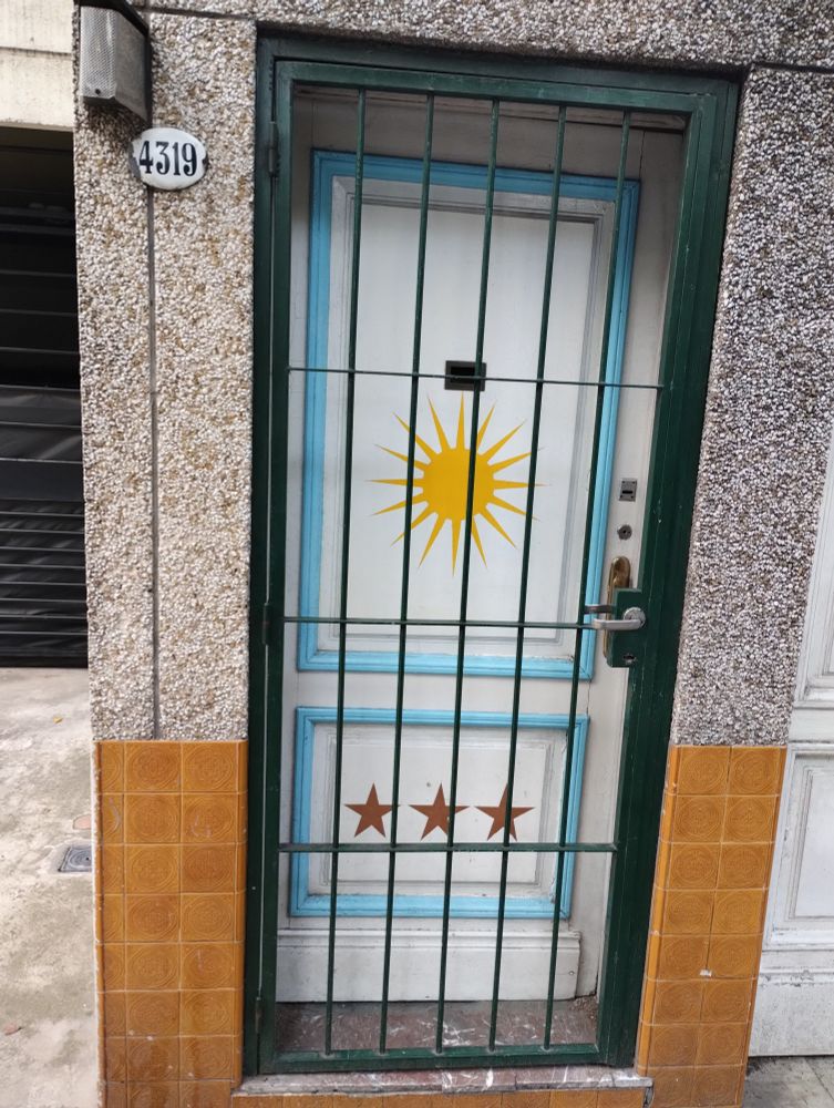 puerta pintada de la bandera argentina con las tres estrellas 