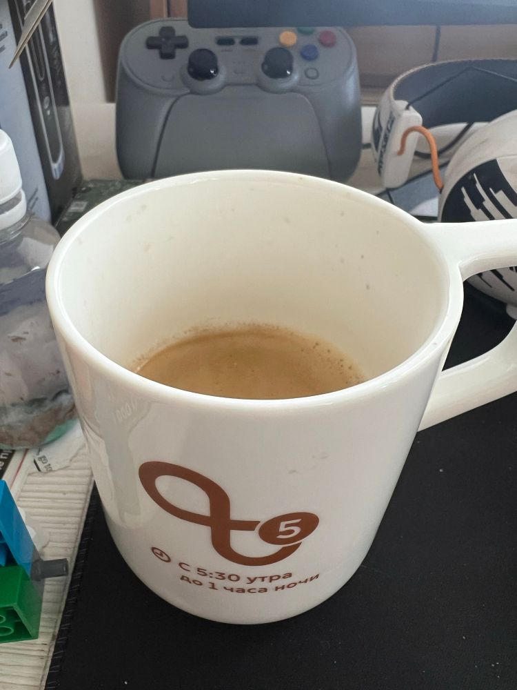 Чашка кофе, геймпад и наушники на столе