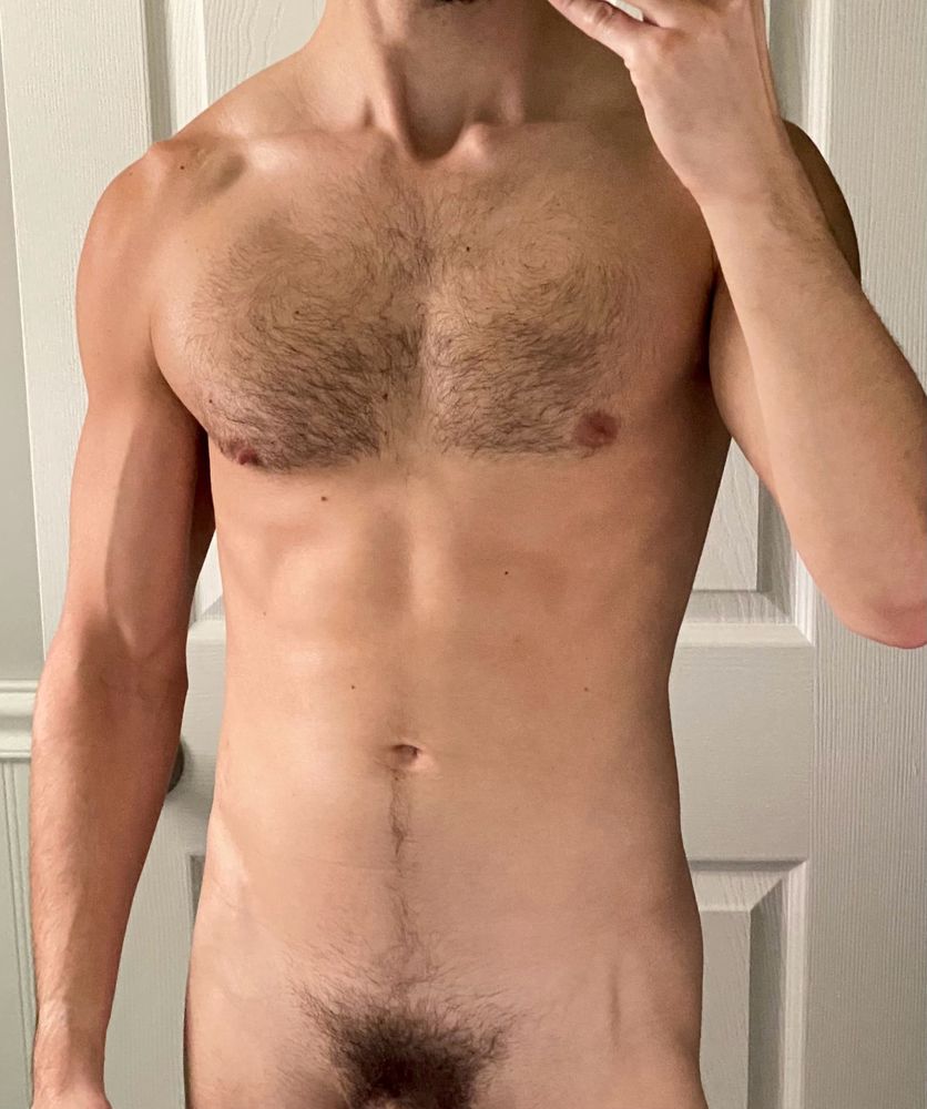 Naked man’s torso showing pubes and hairy chest.