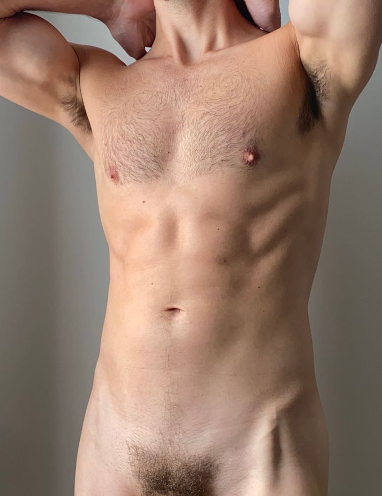 Torso of a nude man with arms upraised to show pit, cropped from shoulders to bush. 