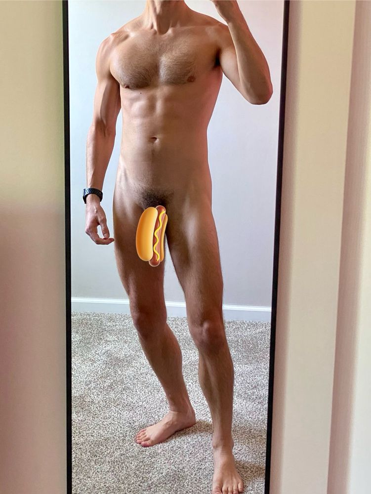 A naked man with a hot dog emoji covering his penis. 