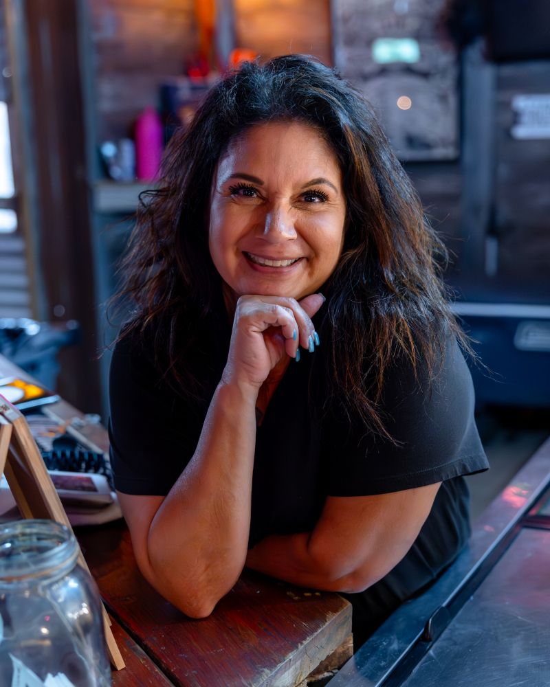 A portrait of a smiling dark-haired bartender 