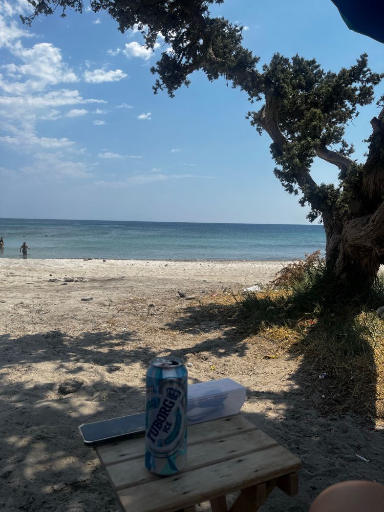 sunny beach and a beer can on a small table 