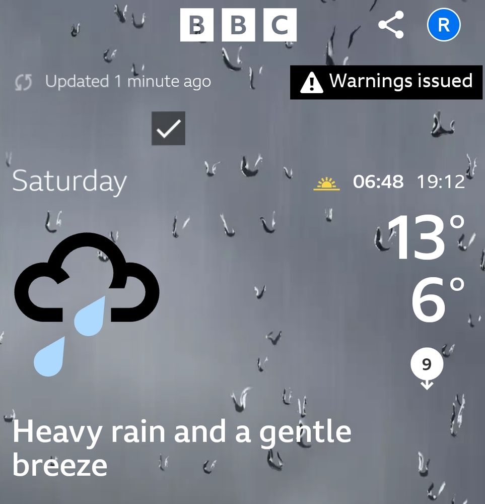 Screenshot of the BBC Weather app showing Saturday the 20th of Septembers weather. On the left there is a picture of a dark cloud with two raindrops. Underneath the rain cloud it says "Heavy rain and a gentle breeze". On the right it shows the sunrise time of 06:48 and sunset time of 19:12. It also shows the temperature of a high of 13°C and a low 6°C with a southerly wind speed of 9mph. On the top left it says "Updated 1 minute ago" and on the top right in a black box with a triangle with an "!" and text saying "Warnings issued" when tapped on, shows a Yellow Weather Warning for rain. 