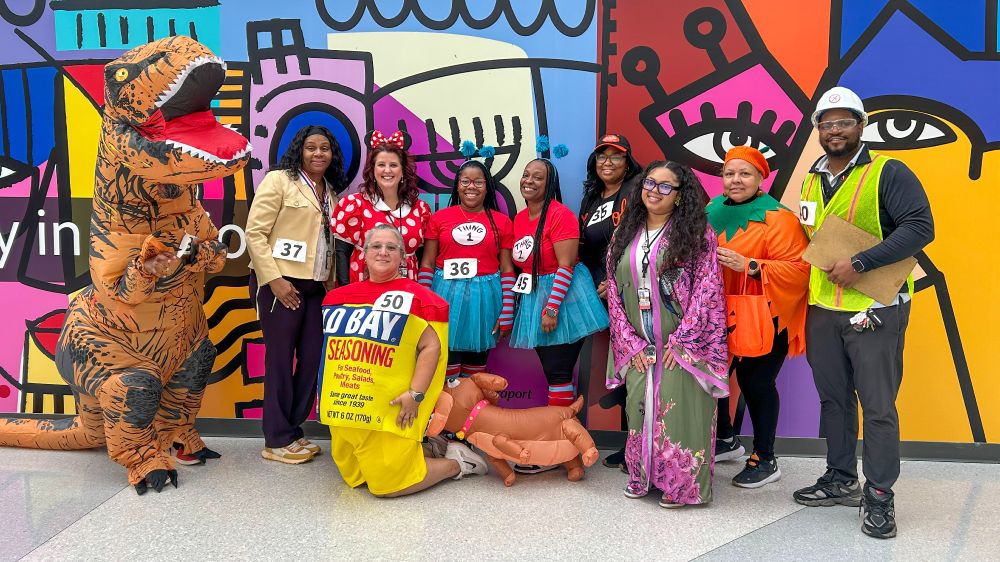10 costumed Maryland Aviation Administration employees posing for a group photo during a safety walk at BWI Thurgood Marshall Airport.