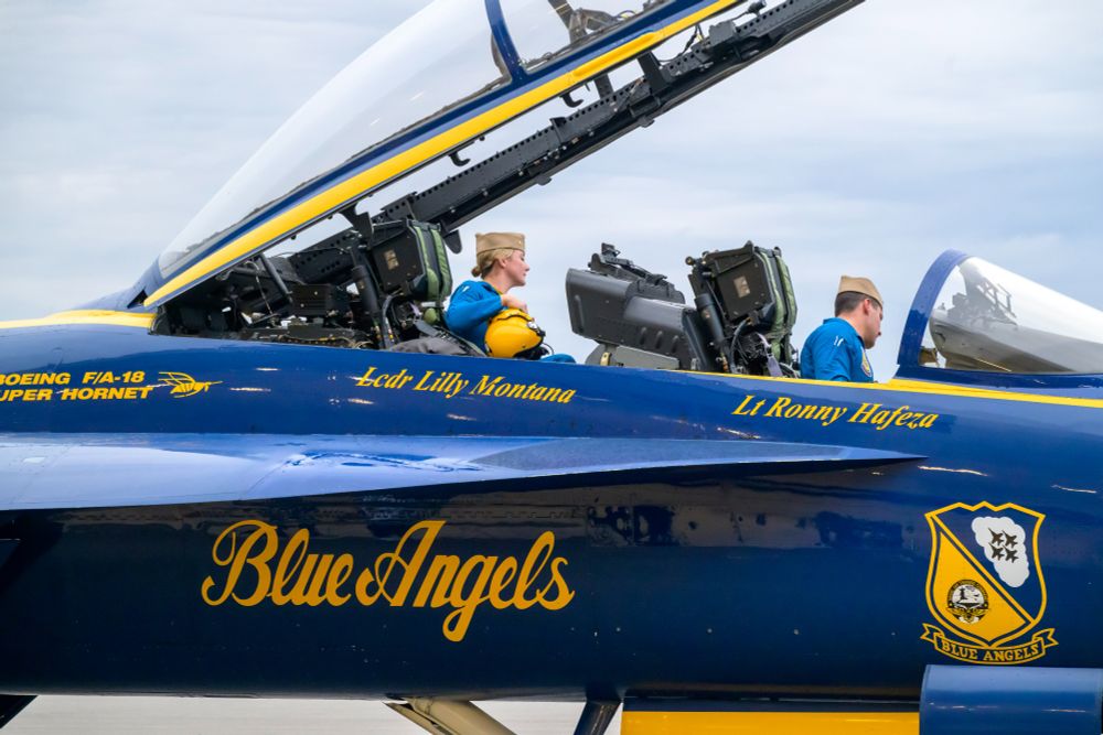 Photo of two members of the U.S. Navy Blue Angels sitting in the cockpit of an aircraft that just arrived at Martin State Airport.