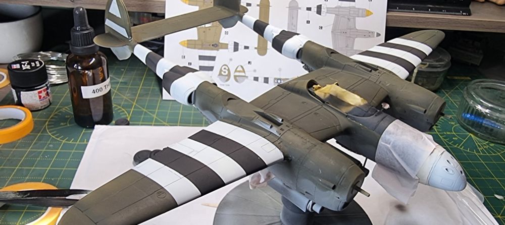 Work in progress model kit of a P38 with D-Day Invasion stripes spray painted.