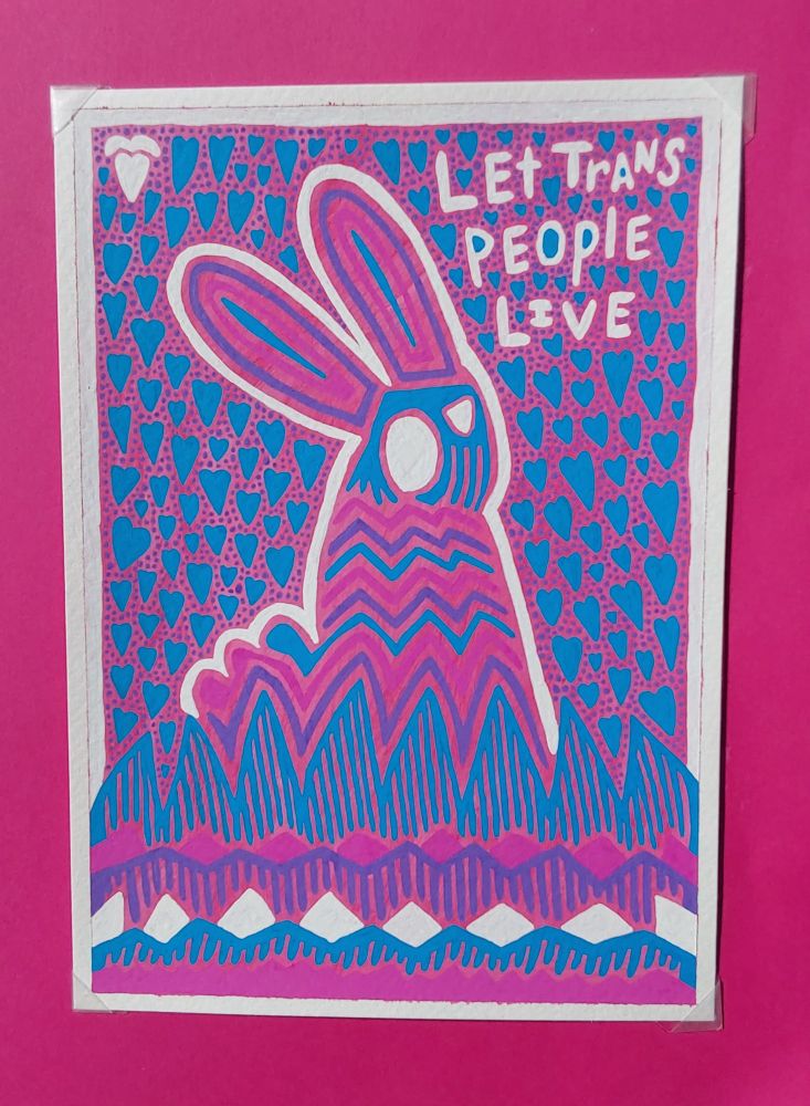 A purple, rose, and blue bunny with white linework is in a field. For this moment, it is calm. 
The grass is an abstracted blue, rose purple, and white linework. Around the bunny are blue hearts and purple dots. In white letters, it reads, "Let trans people live."
This is a 4x6. You can get it for 25. Dm for more info. 