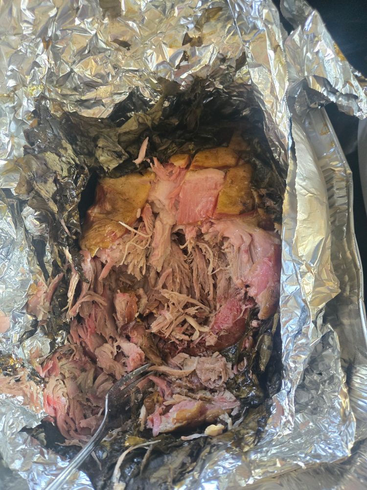 One of the pork butts. Cooked a bit fast and lost some juices that were kept safe in the aluminum pan I put it in. Damn good pulled pork, though it mostly tasted like (very good) regular pulled pork to me. Nice and tender, good smoke color, decent smoke and salt flavor. Not sure the Taro leaves added much, but they at least add some visual disti ction when shredded up. Damn good smoke.