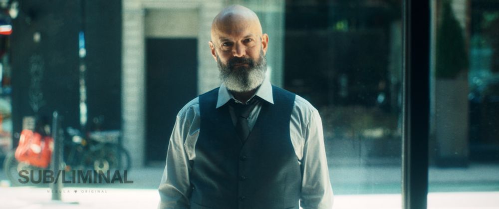 Man in a window wearing a tie