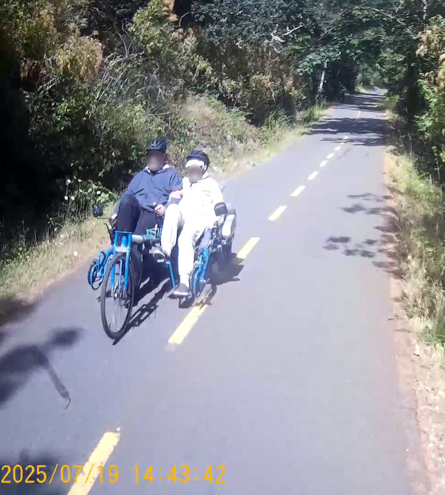 Oncoming side by side tandem recumbent bicycle on a multiuse trail.