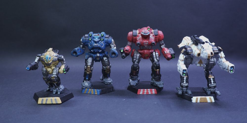 4 Battletech miniatures painted in Super Sentai like colors, with a yellow Spectre, blue Gunslinger, red Thunder Hawk, and white Marauder II. The color scheme combines the primary color, with silver, black, and gold accents.