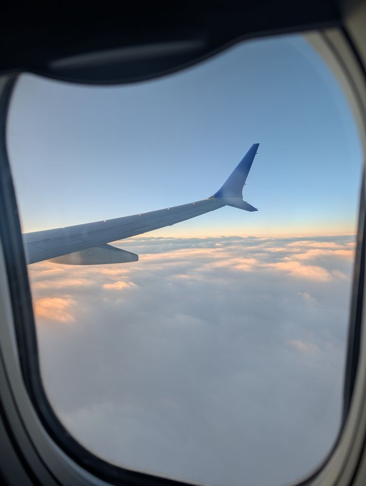 Picture of the top of clouds out a plane window