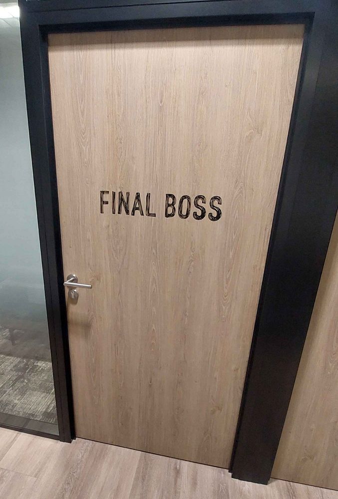 Porte du bureau d'Oskar Guilbert dans les locaux de Don't Nod, avec une inscription Final Boss