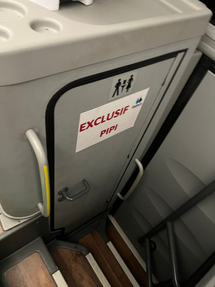 Porte des toilettes d’un bus avec un panneau « exclusif pipi » de bon aloi
