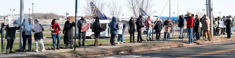 A long line of Avelo protestors standing with signs outside of the Tweed New Haven Airport.