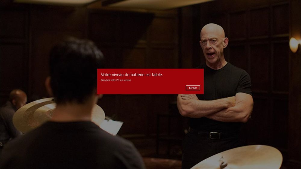 Une capture d'écran du film Whiplash ou John K. Simmons semble énervé contre Miles Teller.

Au centre, une alerte d'ordinateur annonçant "Votre niveau de batterie est faible."

Ba dum tss!