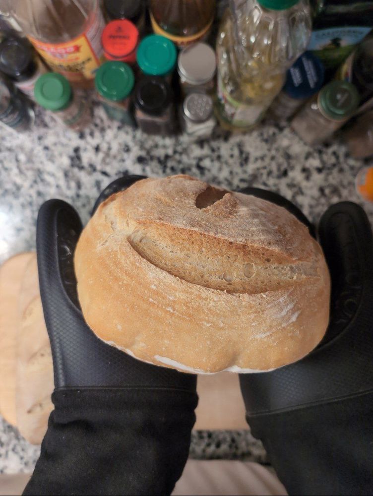 a side view of a golden brown boule. thick slashes are on the side