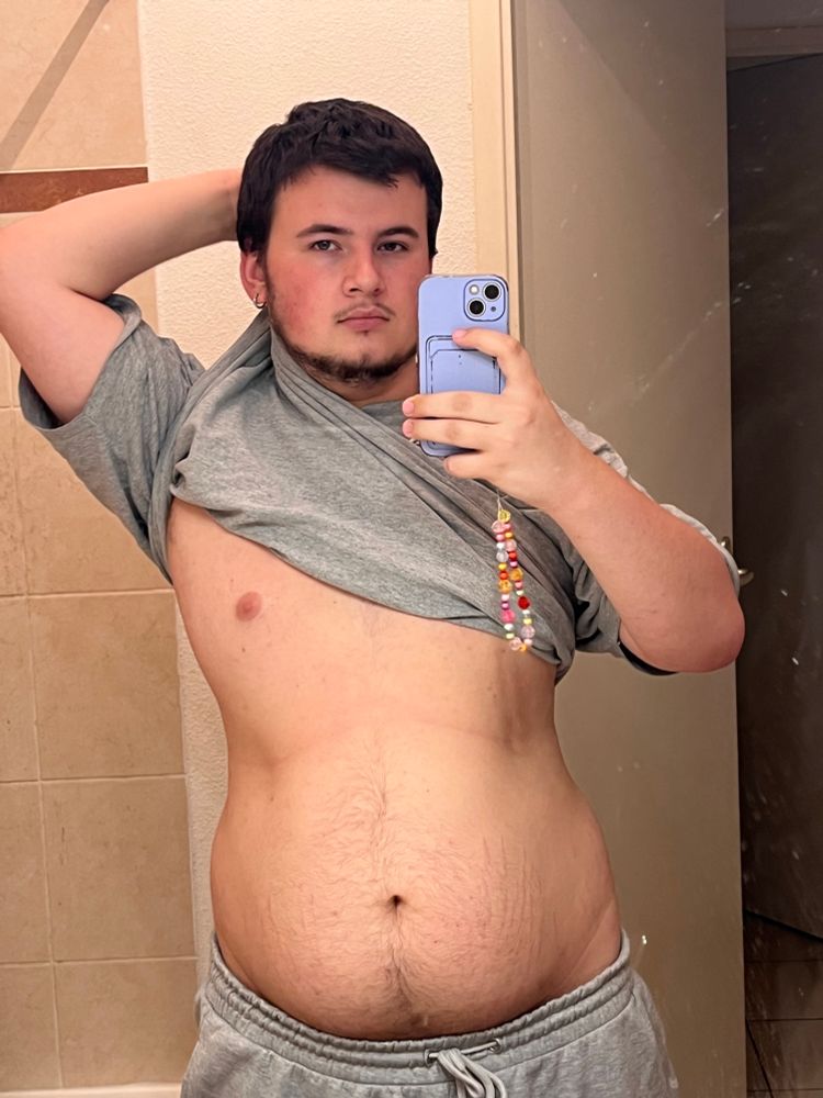 Jeune homme sexy avec du bidou qui tient la pose avec un tee shirt lever