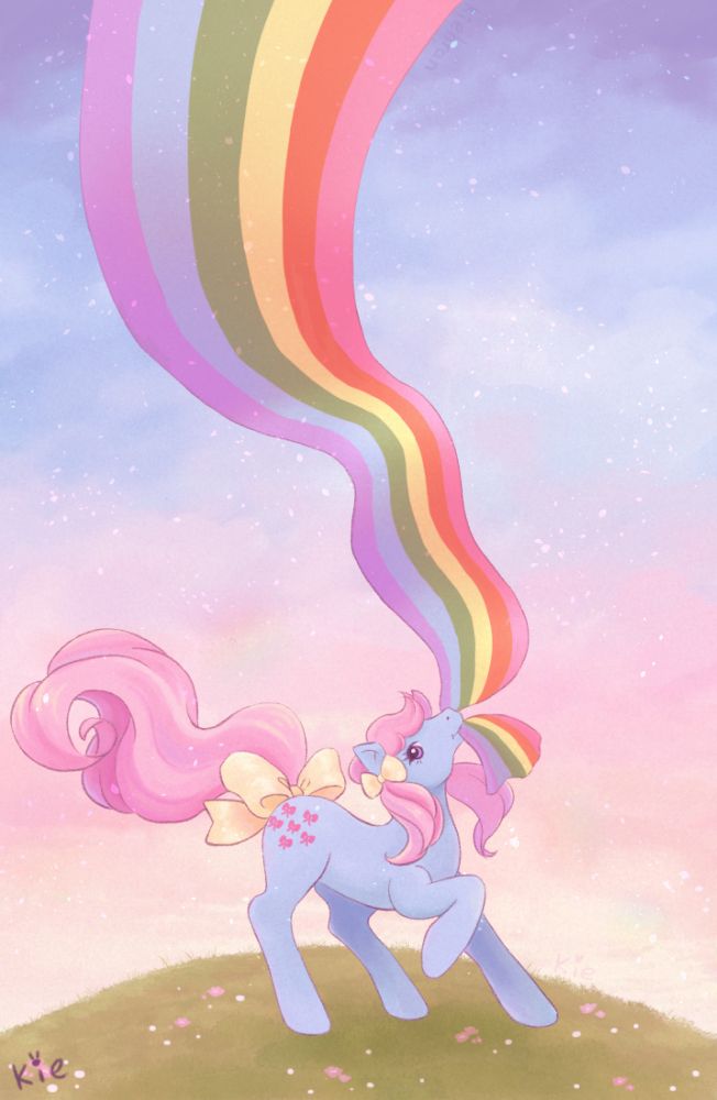 Gen 1 pony Bow Tie (Blue body + pink hair with yellow ribbons) holding onto a large streamer like ribbon with the colours of the Rainbow of light(G1) in her mouth. She is standing on top a hill with a pastel morning sun background.