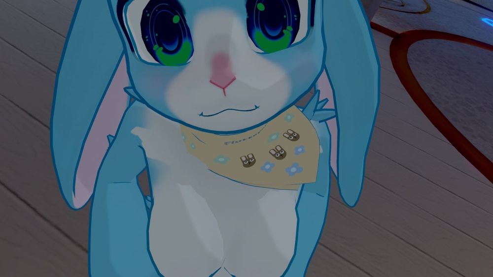 Fluttercute the blue bunny has a blue fur coat with a white belly that leads up to her face and over the mouth and nose. She has green and blue eyes, and has a cute bandana with bunnies and flowers on it along with the text "Fluttercute"