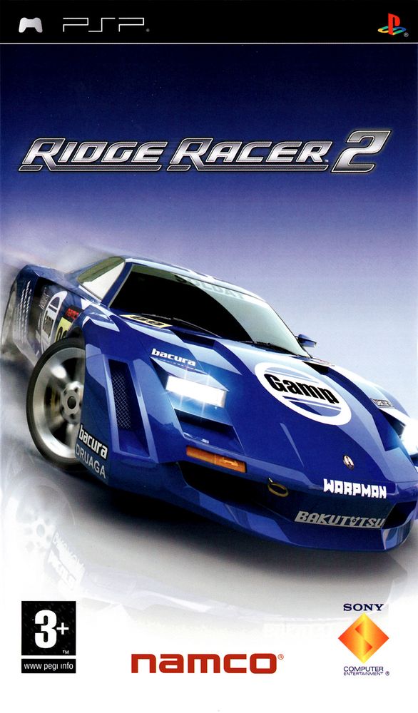 Ridge Racer 2 PSP (2006) European box art. The PSP logo banner is at the top. The silvery, sleek game logo rests on a dark blue gradient which becomes a reflective white showroom surface background. The focus of the art is a blue racecar with sponsored livery drifting sideways. It is turning right while our perspective is to the front and right of the car. Below from left to right, are PEGI rating (3+), the Namco logo, and the old orange diamond Sony Computer Entertainment logo.