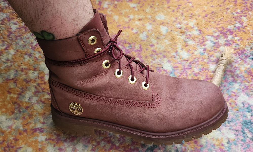 The outer side of the right boot. There is a gold Timberland logo placed by the heel of the boot just above the sole.