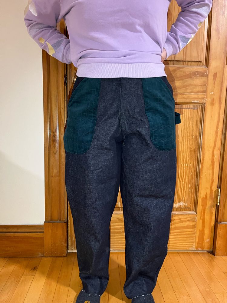 my lower half, wearing somewhat baggy dark denim pants with dark green corduroy front pockets. there’s also a hammer loop made out of dark green corduroy