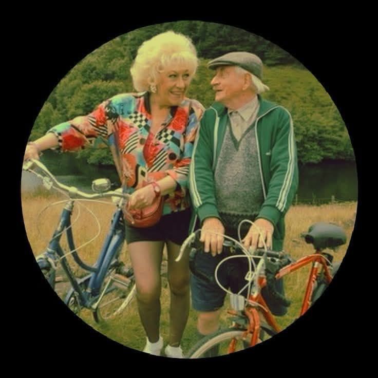 The characters Howard and Marina from the TV series Last Of The Summer Wine, gaze lustfully into each other’s arms while pausing on a cycle ride.