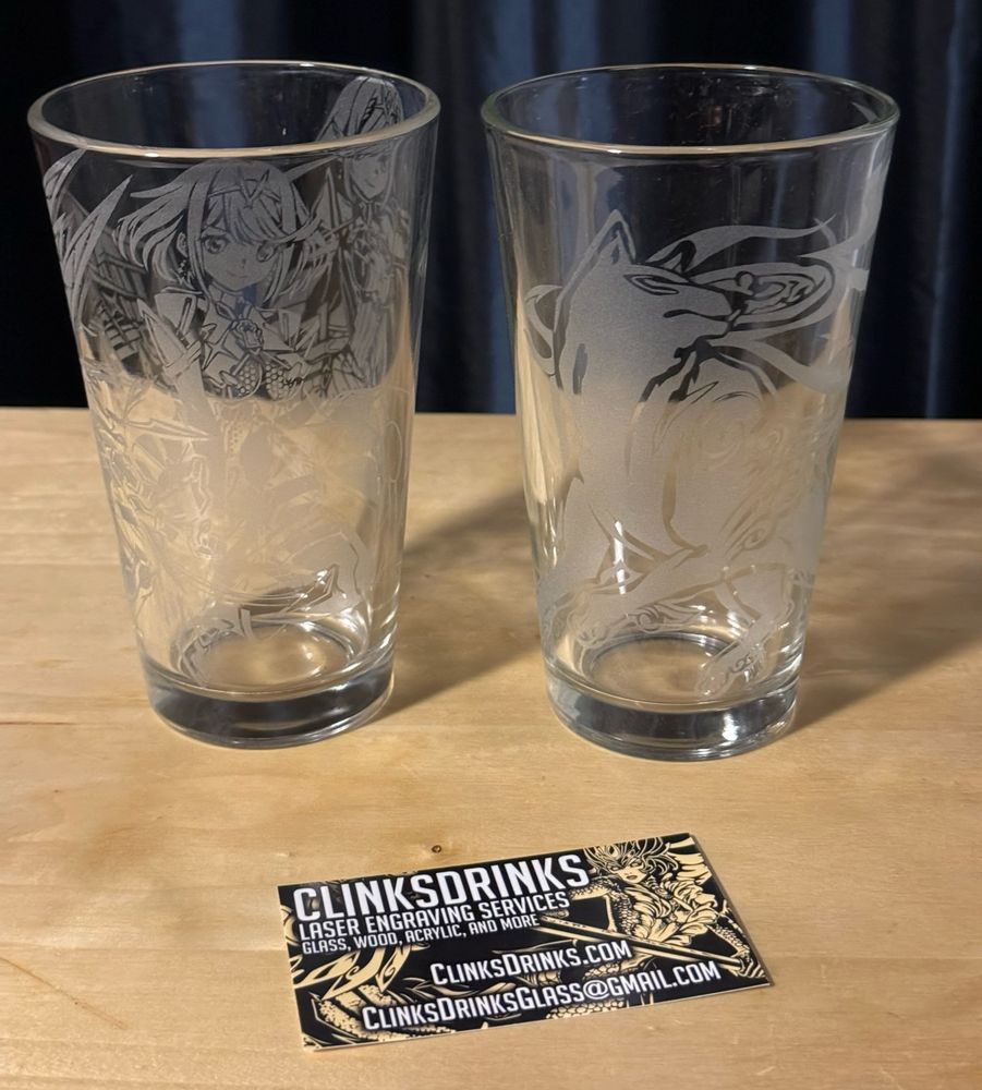 One glass with Pyra & Mythra, the other glass with Amaterasu, and a business card for ClinksDrinks.