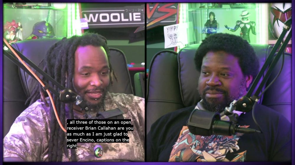 Woolie and Reggie sit on a couch talking on the 10/17/25 episode of the Woolie Versus show, where subtitles are indicating that Woolie has said

", all three of those on an open receiver Brian Callahan are you as much as I am just glad to sever Encino, captions on the right"