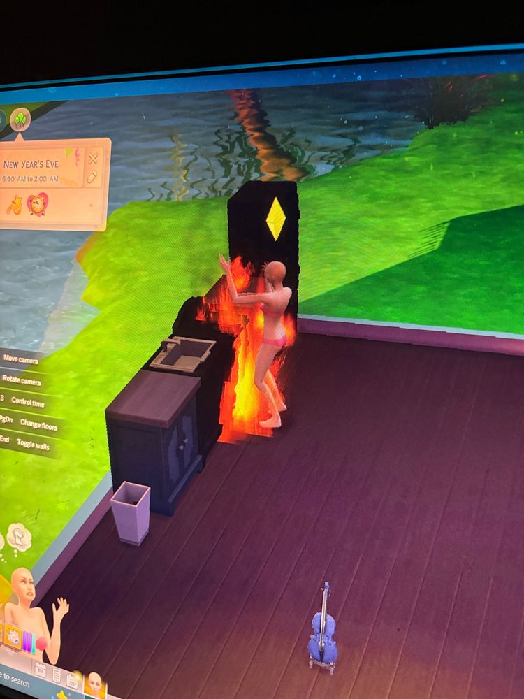 Image of gameplay from The Sims 4 where a sim is on fire after attempting to cook. 