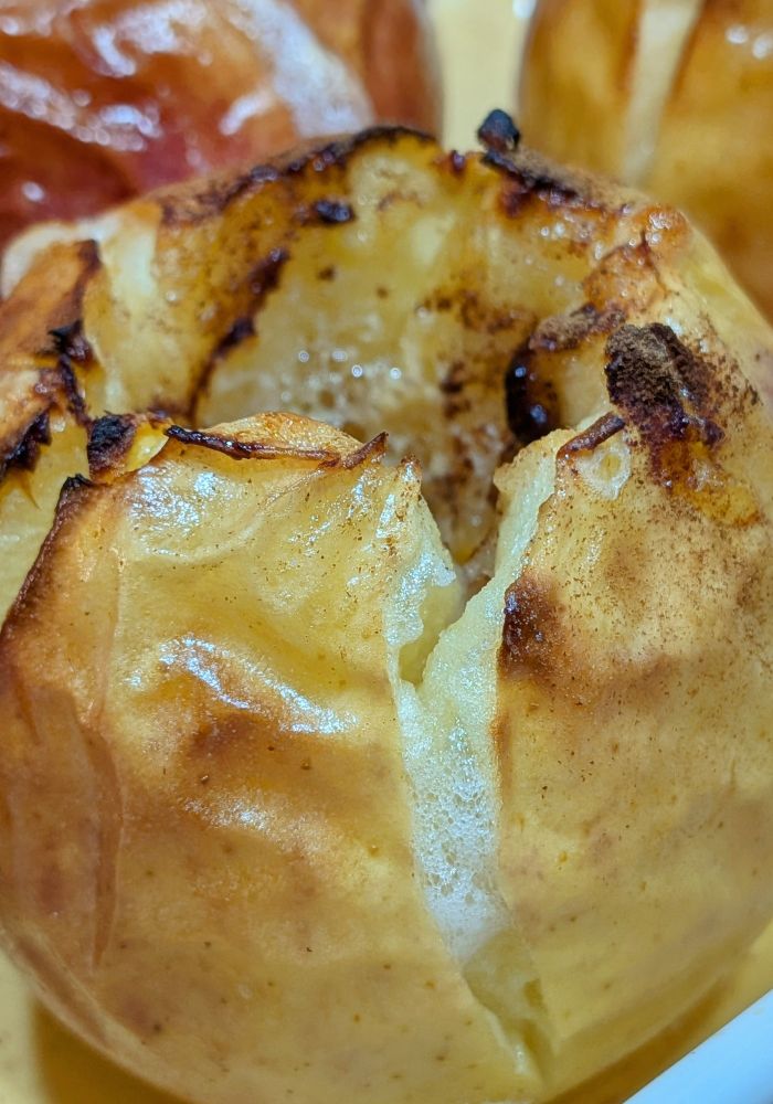 Les pommes au sortir du four, la peau a éclaté et une mousse s'échappe des fissures 