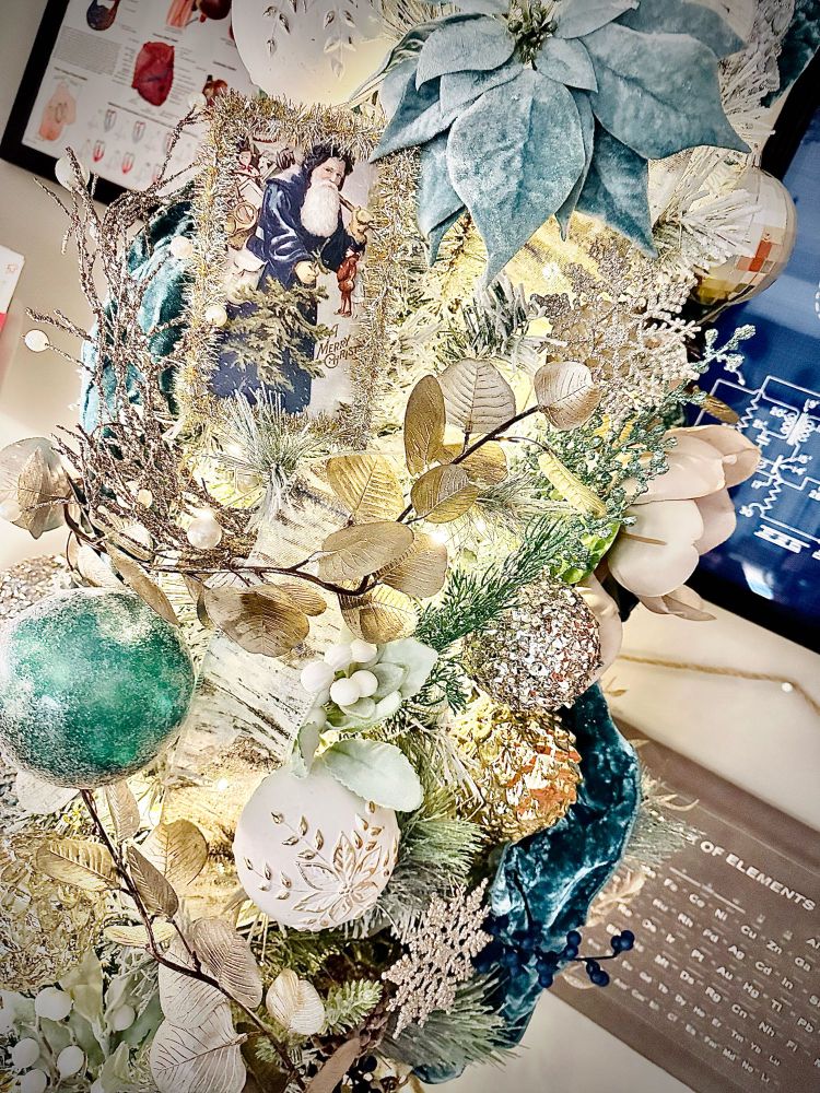 Closer view of the blue, green, cream, and champagne gold Christmas tree ornaments