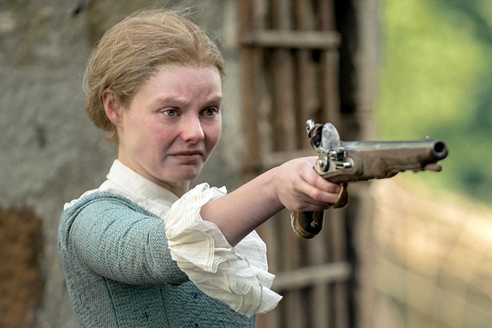Laoghaire from outlander pointing a pistol from the 1760s at someone to the left. She is angry. (She does in fact shoot someone in this scene)