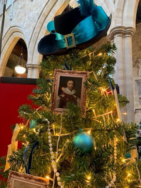 Close up of a Christmas tree decked with miniature portraits of George Villiers, baubles, strings of pearls and topped with a 17th century style hat