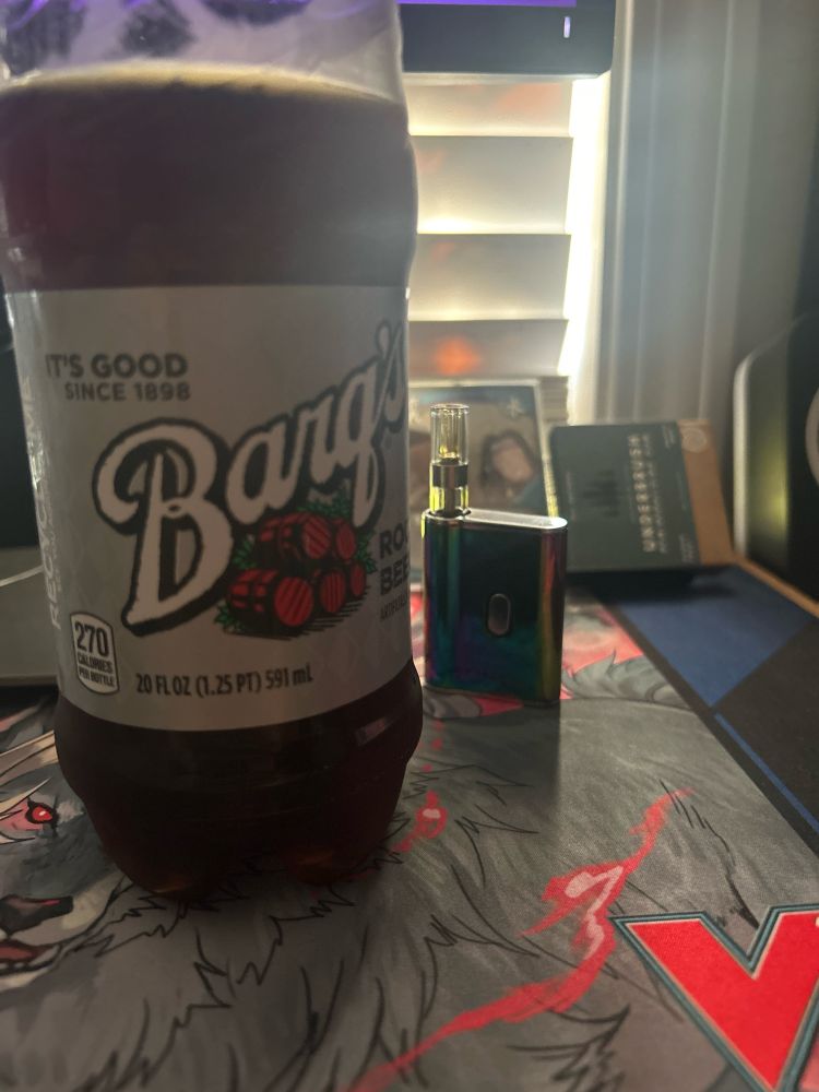 a barqs root beer next to a thc cart in front of a window