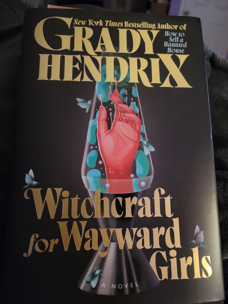 The cover of Witchcraft for Wayward Girls by Grady Hendrix, featuring a disembodied red hand floating in a lava lamp.