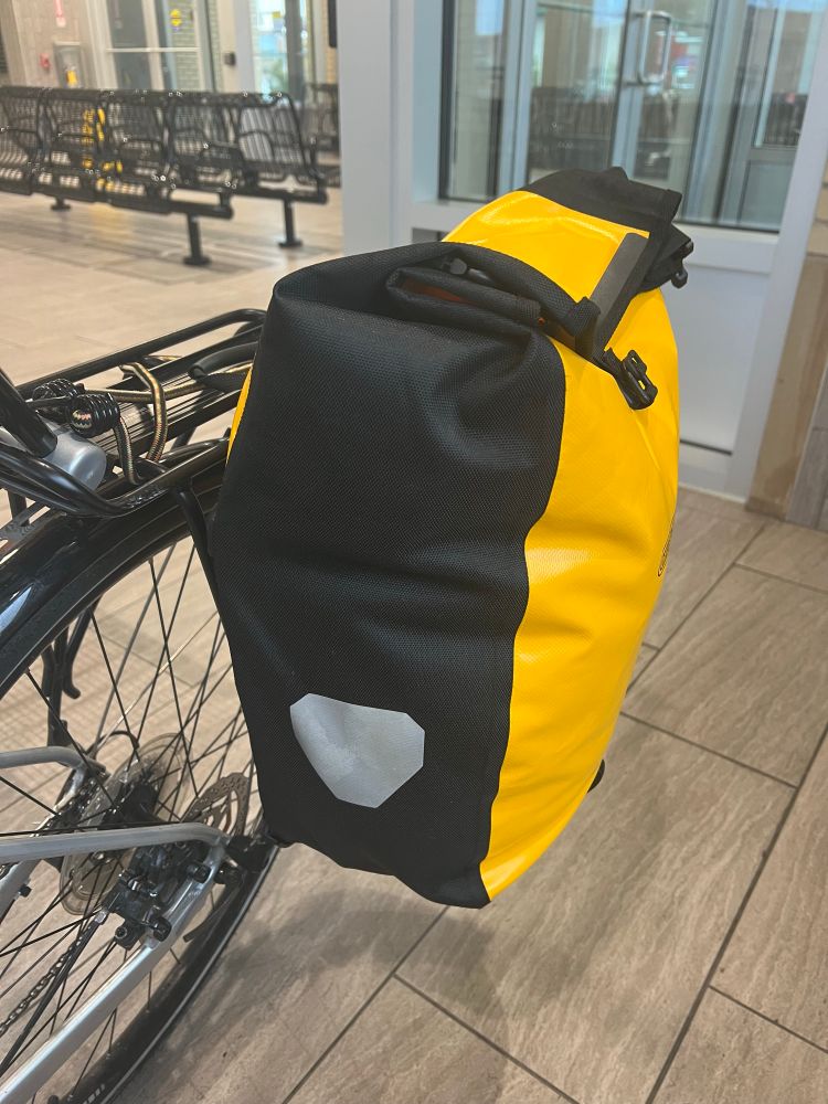 A pannier, mounted on the side of a bike, and overstuffed AF