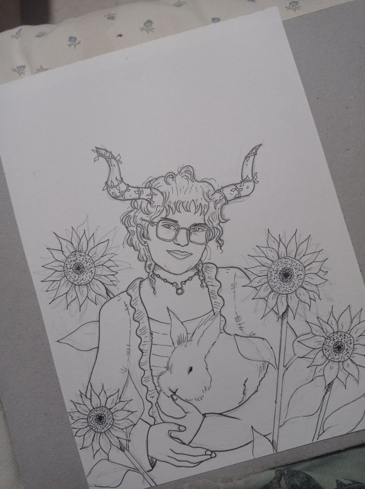 Dibujo entintado de una chica con cuernos, rodeada de girasoles y con un conejo entre los brazos. 