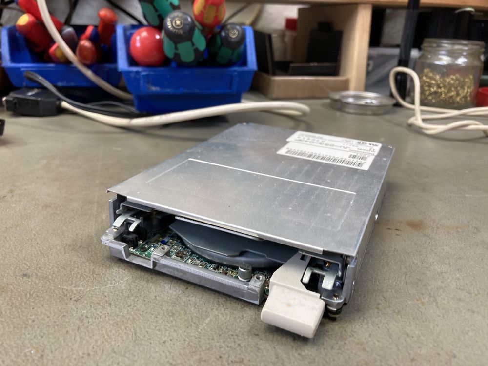 The Panasonic floppy disk drive from my Amiga 600 on my workbench, removed from the Amiga.