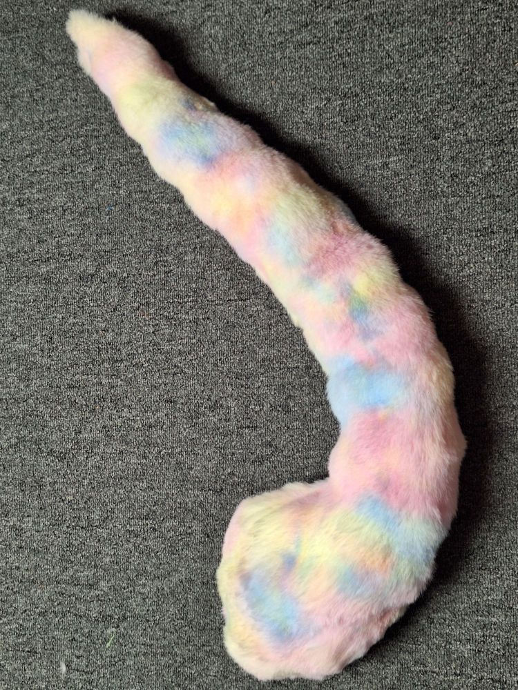 A large multicolored (pastel pink blue and yellow) feline tail, with a hidden belt loop. It's made with bubble fur, which makes it look almost like a cloud.