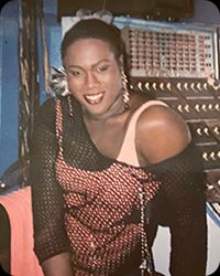 Rita Hester, a black woman wearing a layered top. She has short hair.