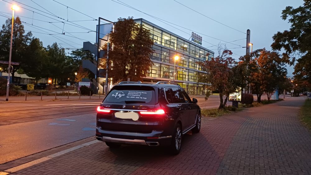 Ein großer BMW-SUV steht im Halbdunkeln auf dem Fußweg der Pfälzer Straße in Magdeburg. 